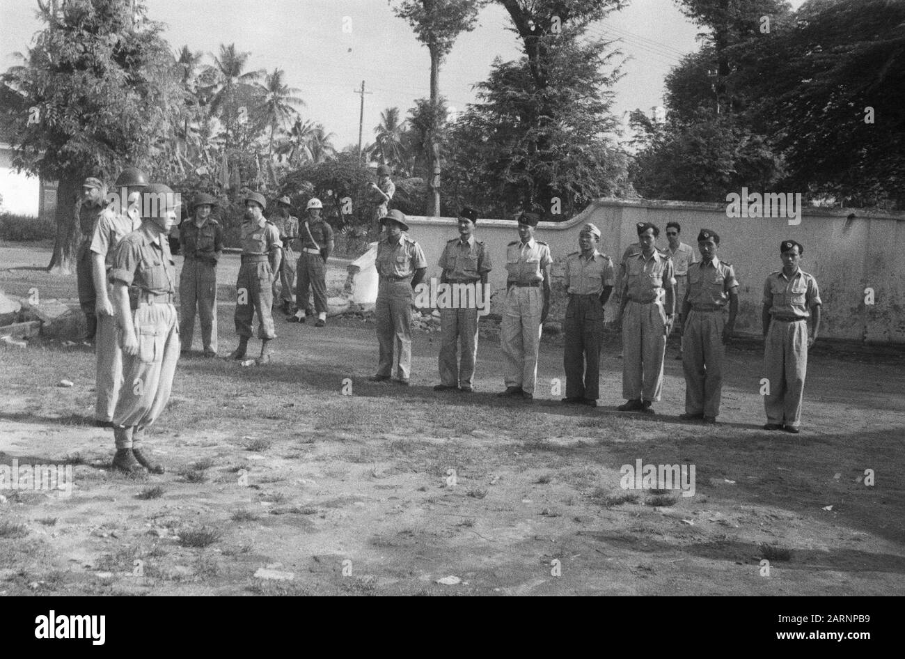 Ritiro truppe olandesi da solo, Gondang Winangoe e Klaten Durante il trasferimento. Ufficiali indonesiani in fila, mentre un comandante plotone olandese ordina durante la cerimonia della bandiera Data: 12 novembre 1949 luogo: Indonesia, Java, Indie orientali olandesi Foto Stock