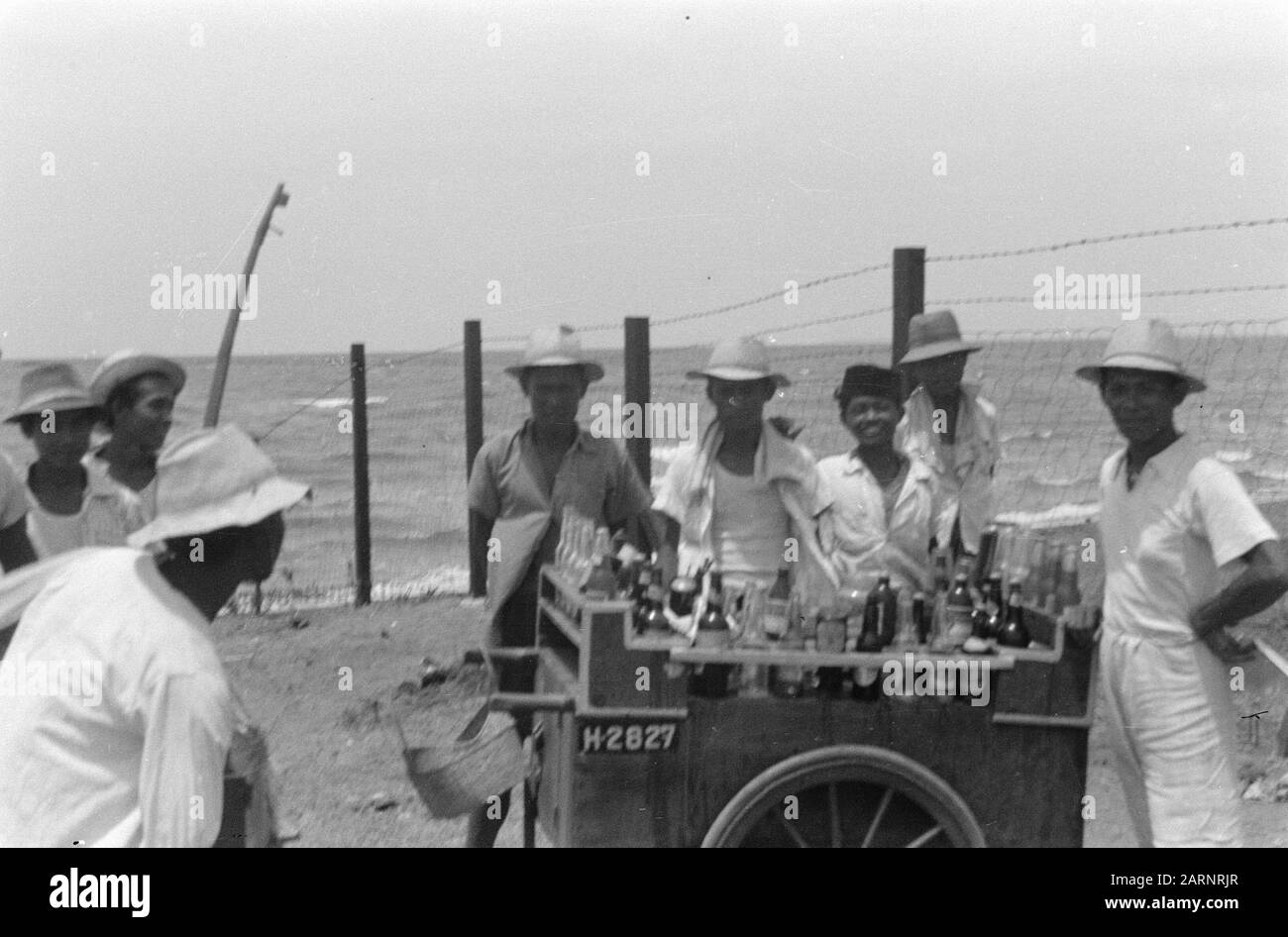 Palmbeach, foto con l'articolo 'Soldier prende vacanza' per la rivista Brothers of Arms Per i militari di stanza in Batavia, Palm-Beach, a Priok, è il luogo dove trascorrono molte domeniche libere. Palm-Beach ha ancora una certa somiglianza con le stazioni balneari olandesi, vale a dire per il fatto che pasticceri e bevande trovano un buon punto di ristoro lì. Tuttavia, qui è 'orang Betaw' che guidano le cose e la tenda della limonata ha un esterno differente che la tenda della spiaggia, ma saporita sono le bevande Data: 13 ottobre 1948 posizione: Indonesia, Java, Indie orientali olandesi, Tandjong Priok Foto Stock