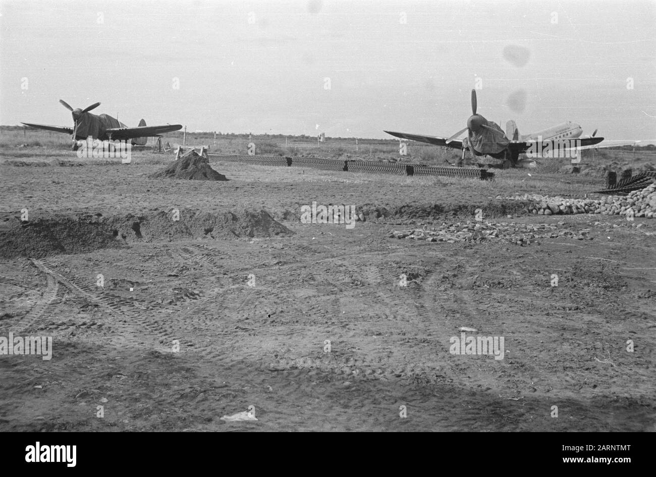 Airbases Aeroporto Di Calibanteng A Semarang. Lavori di movimento terra. Due aerei da combattimento Curtiss P40 sotto i teloni Data: Aprile 1947 Località: Indonesia, Indie Orientali Olandesi Foto Stock
