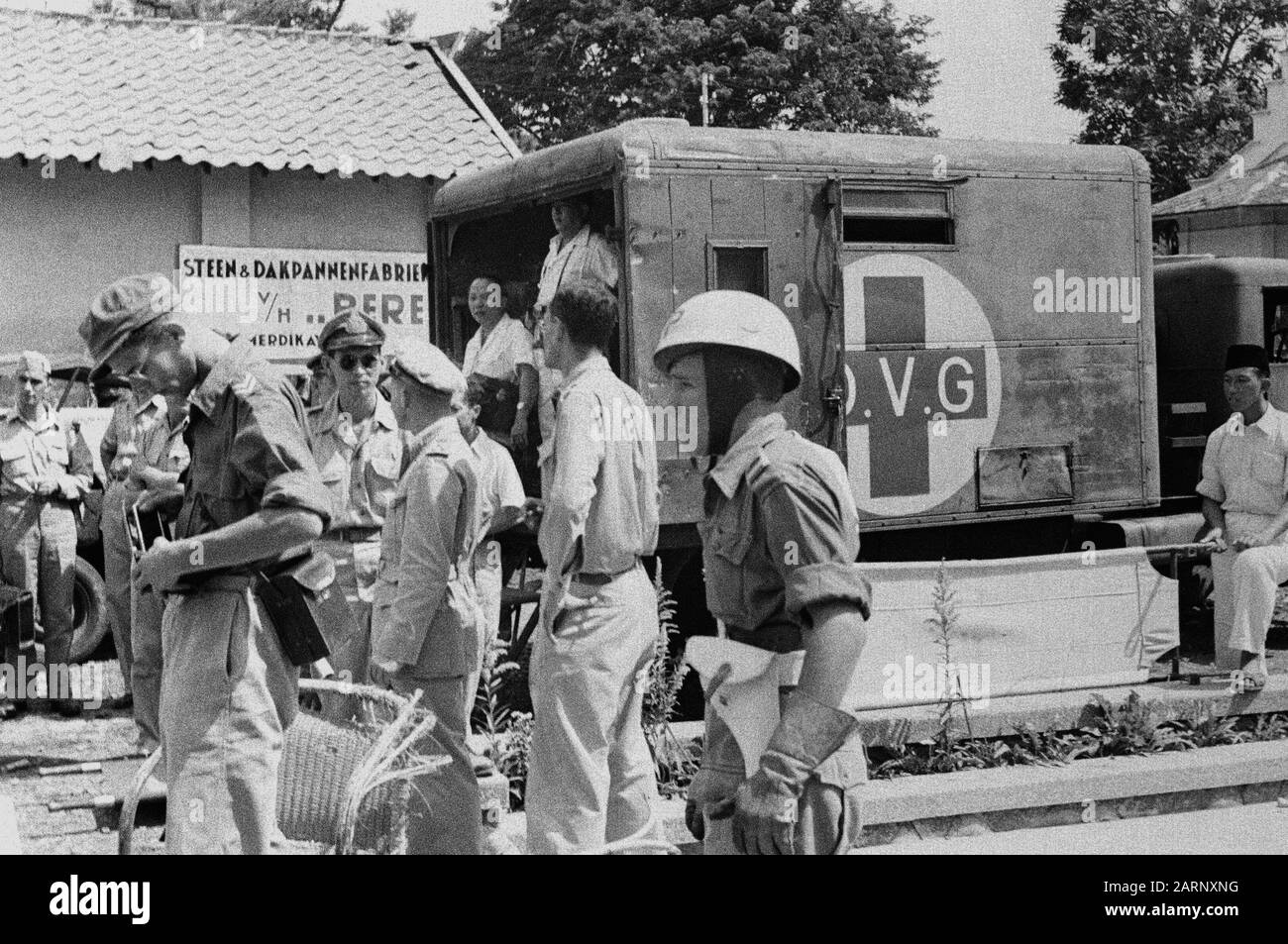 Un'ambulanza con croce rossa e scritta O.V.G. si trova in una fabbrica di piastrelle di pietra e tetto (v/h... Pere?) Data: Dicembre 1948 Luogo: Indonesia, Indie Orientali Olandesi Foto Stock