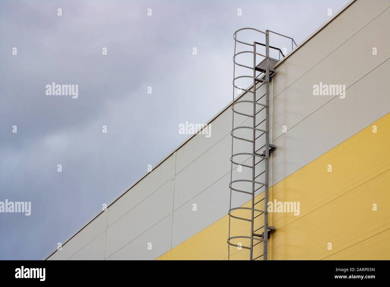 Scala al tetto di un alto edificio su uno sfondo cielo scuro Foto Stock