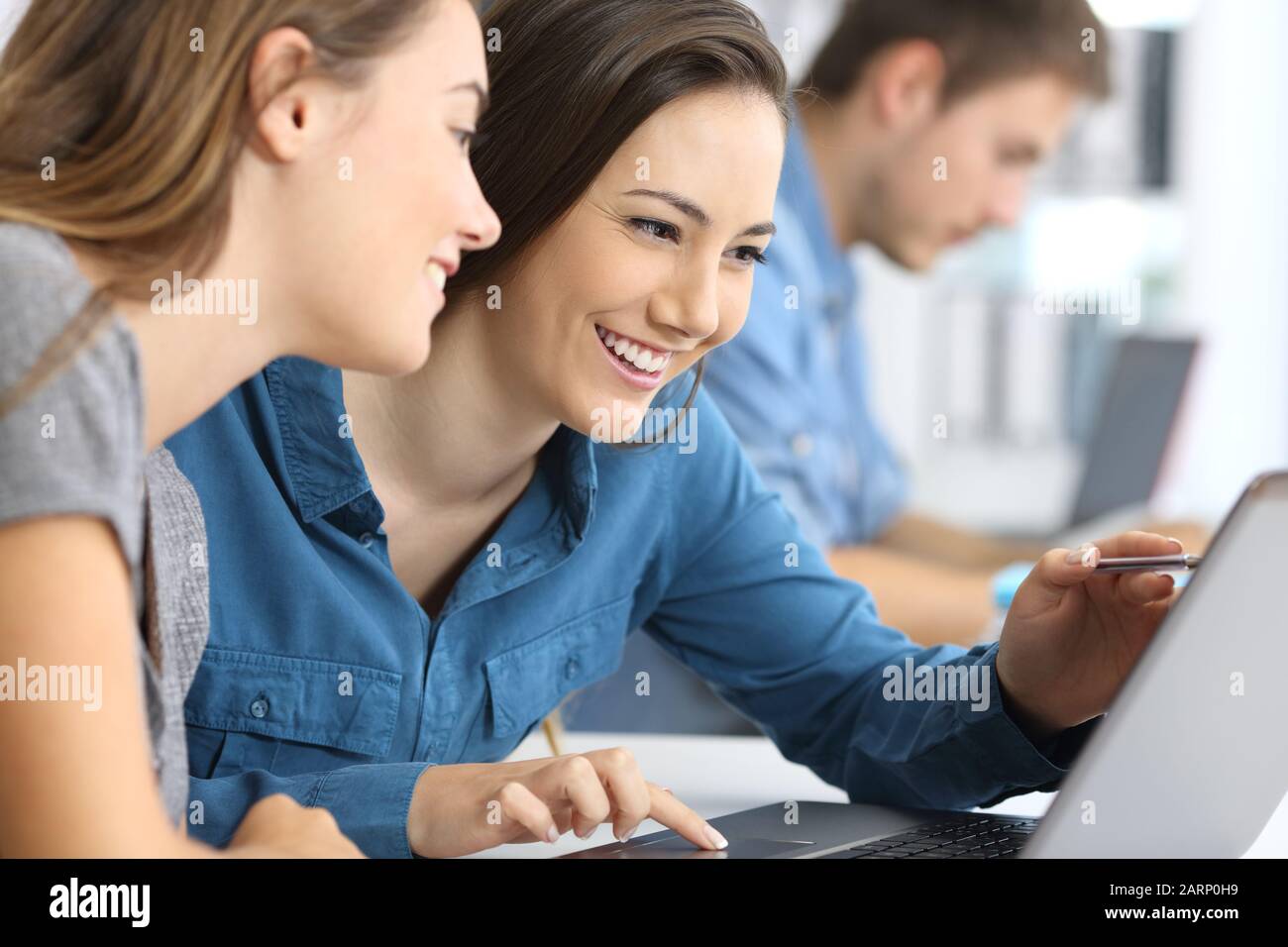 Due dipendenti che lavorano in linea con un notebook in ufficio Foto Stock