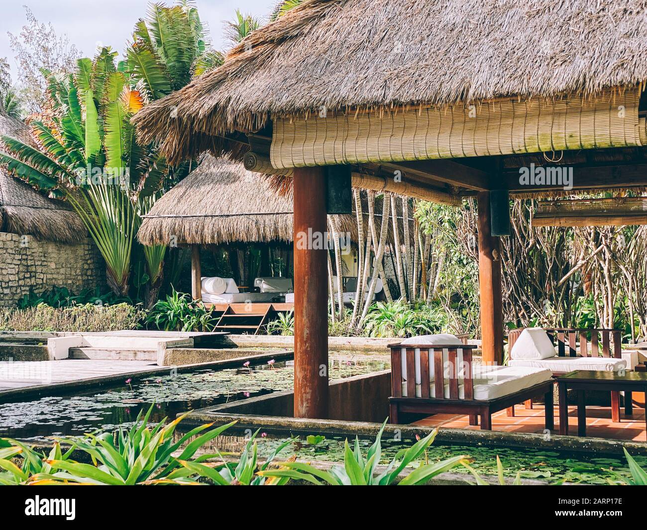 Bungalows in piedi tra vegetazione tropicale, circondato da palme. Un luogo dove rilassarsi e meditare. Rilassatevi in un paradiso tropicale Foto Stock