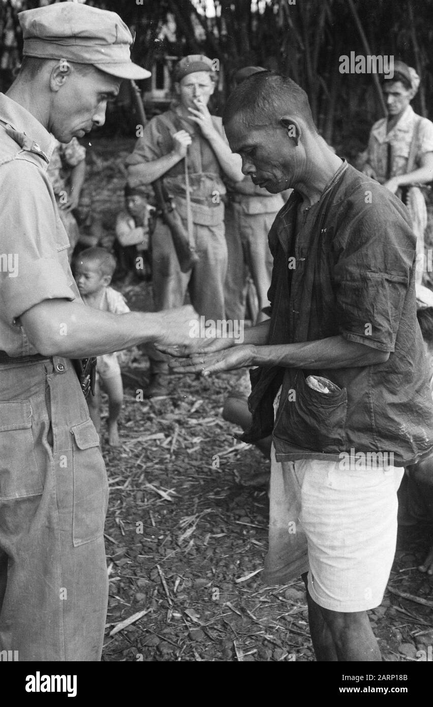 Repubblica: Wanaradja, (?) , Garut, Chibatoe Garut. Captain Nix of the 1st Eskadron Fighters sta investigando un soldato TNI catturato in un'azione di purificazione Annotazione: DJK Data: 5 novembre 1947 Località: Indonesia, Java, Indie orientali olandesi Foto Stock