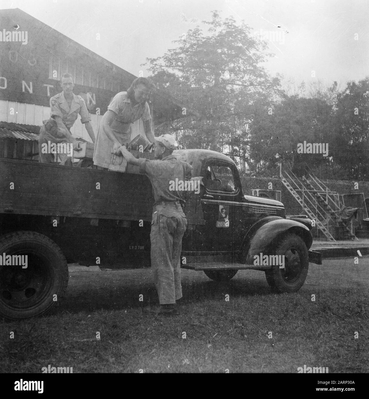 [Gli articoli sono caricati dal corpo di un camion da due uomini e una donna in uniforme] Data: 1947 luogo: Indonesia, Indie orientali olandesi Foto Stock