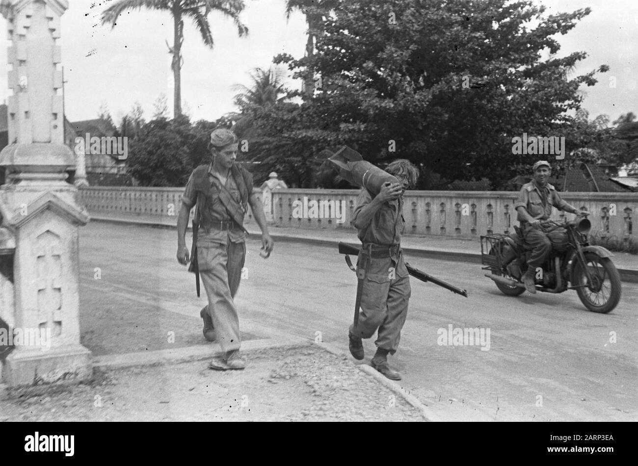 L'occupazione di solo, anticipo della V brigata [Due soldati, uno dei quali con una bomba aereo che cammina sopra la spalla su un ponte. Right a smiling motorordonnans] Data: 21 December 1948 luogo: Indonesia, Indie orientali olandesi Foto Stock