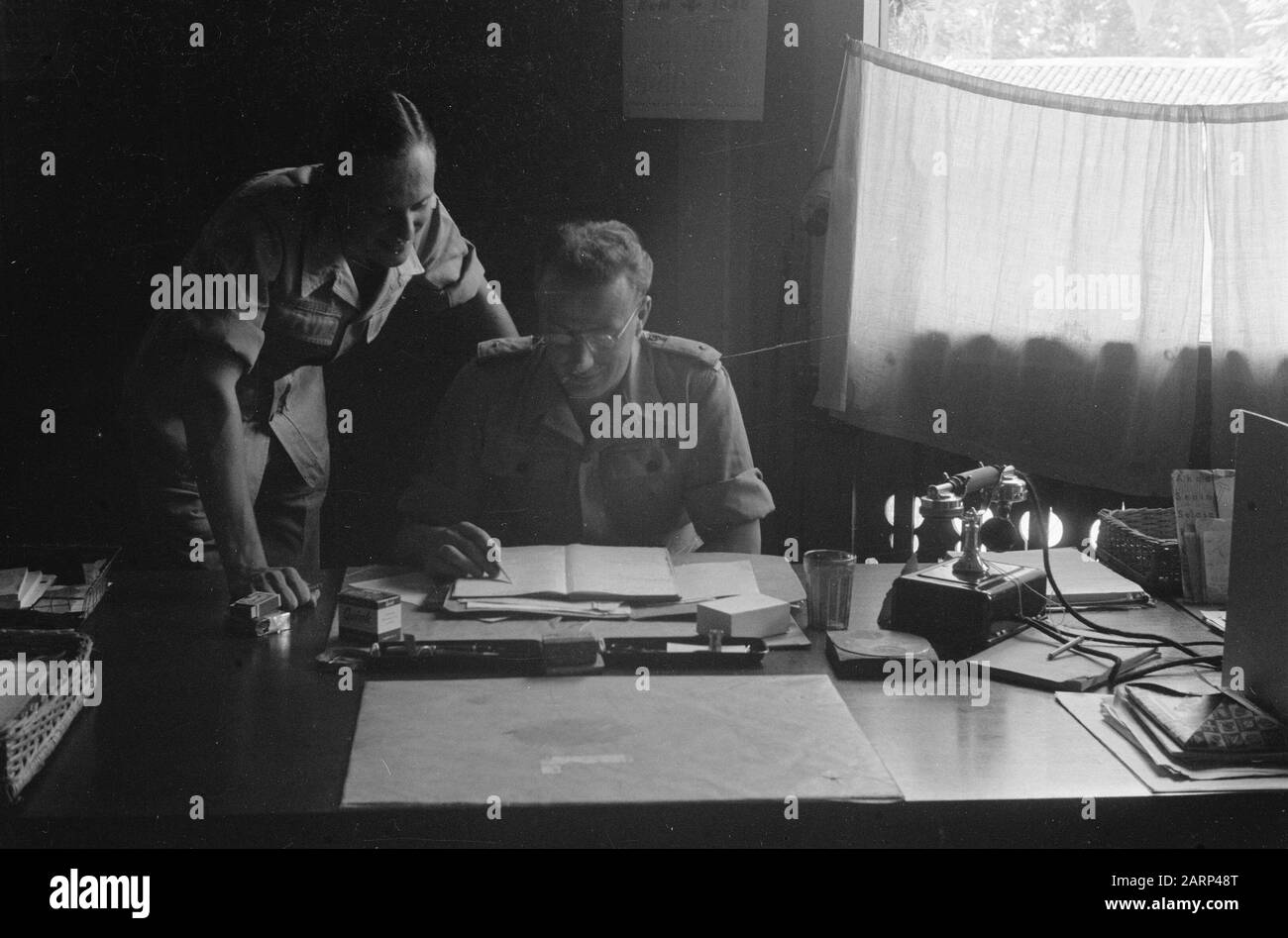 4th Brigata di fanteria pronta per marzo a Wlingi Due soldati, il cui posto è un secondo tenente) si piegano su carte su una scrivania in un ufficio Data : Dicembre 1948 luogo: Indonesia, Indie orientali olandesi Foto Stock