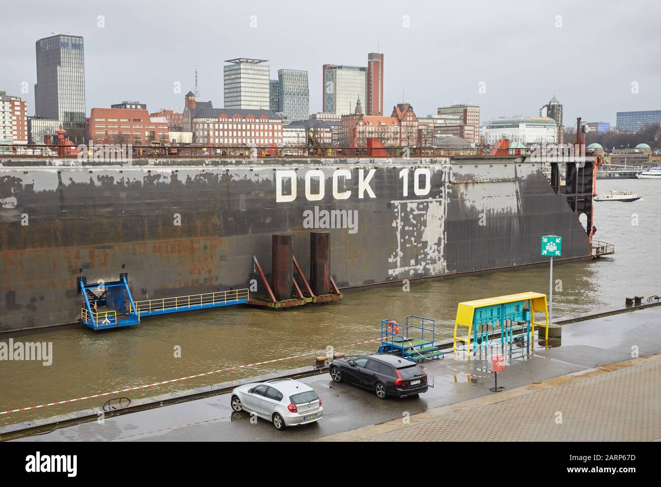 29 gennaio 2020, Amburgo: La scritta "'Dock 10'' è sul molo dello stesso nome di Blohm+Voss. Sullo sfondo si può vedere la torre Astra e le fasi di atterraggio (r). In occasione di una conferenza stampa, il cantiere navale Lürssen ha presentato il suo progetto architettonico per la copertura del Dock 10 a Blohm+Voss. Foto: Georg Wendt/Dpa Foto Stock