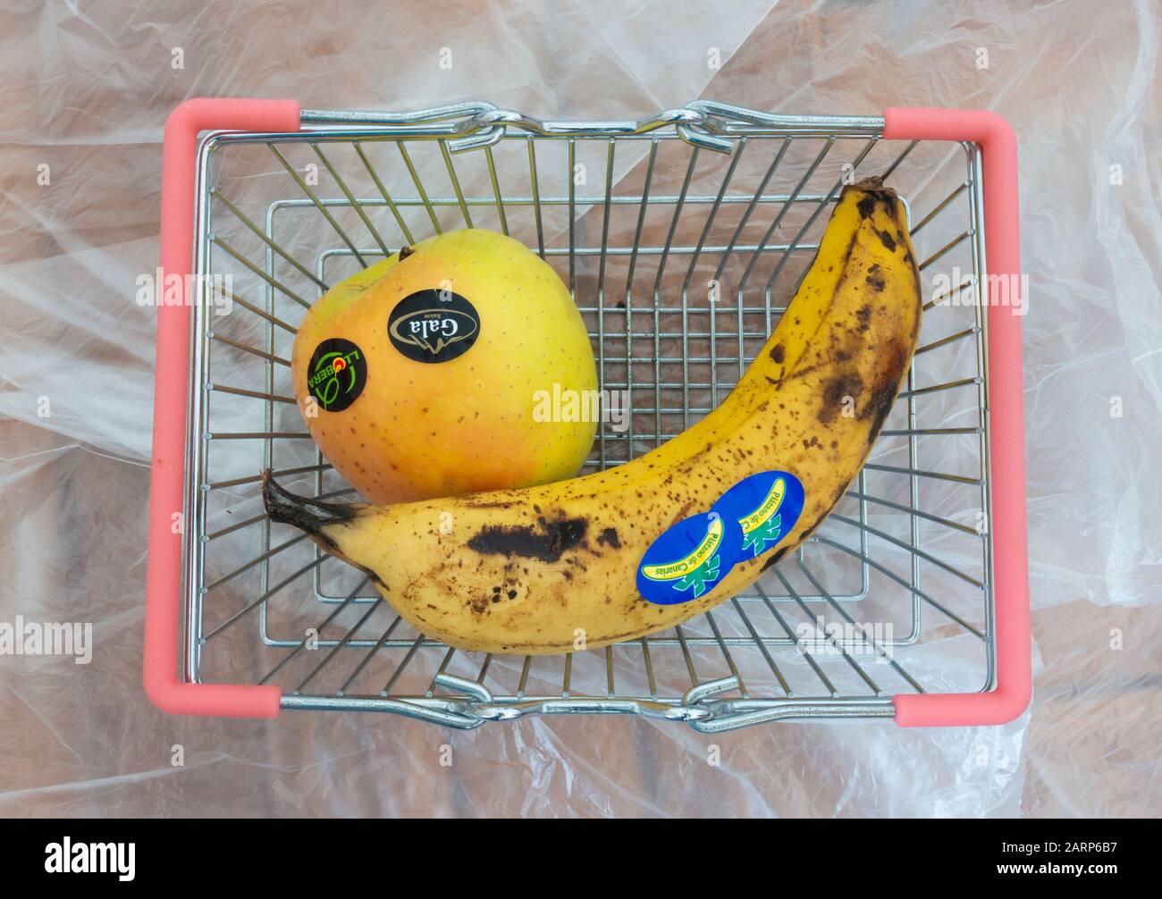 Adesivi in plastica sul supermercato frutta in piccolo cestino su sottili sacchetti di plastica sfondo. Foto Stock