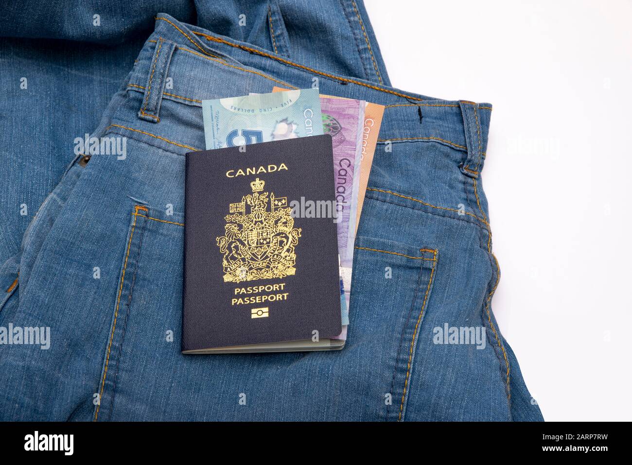 Primo piano canada passaporto e dollaro canadese su Blu jean con spazio copia. Foto Stock