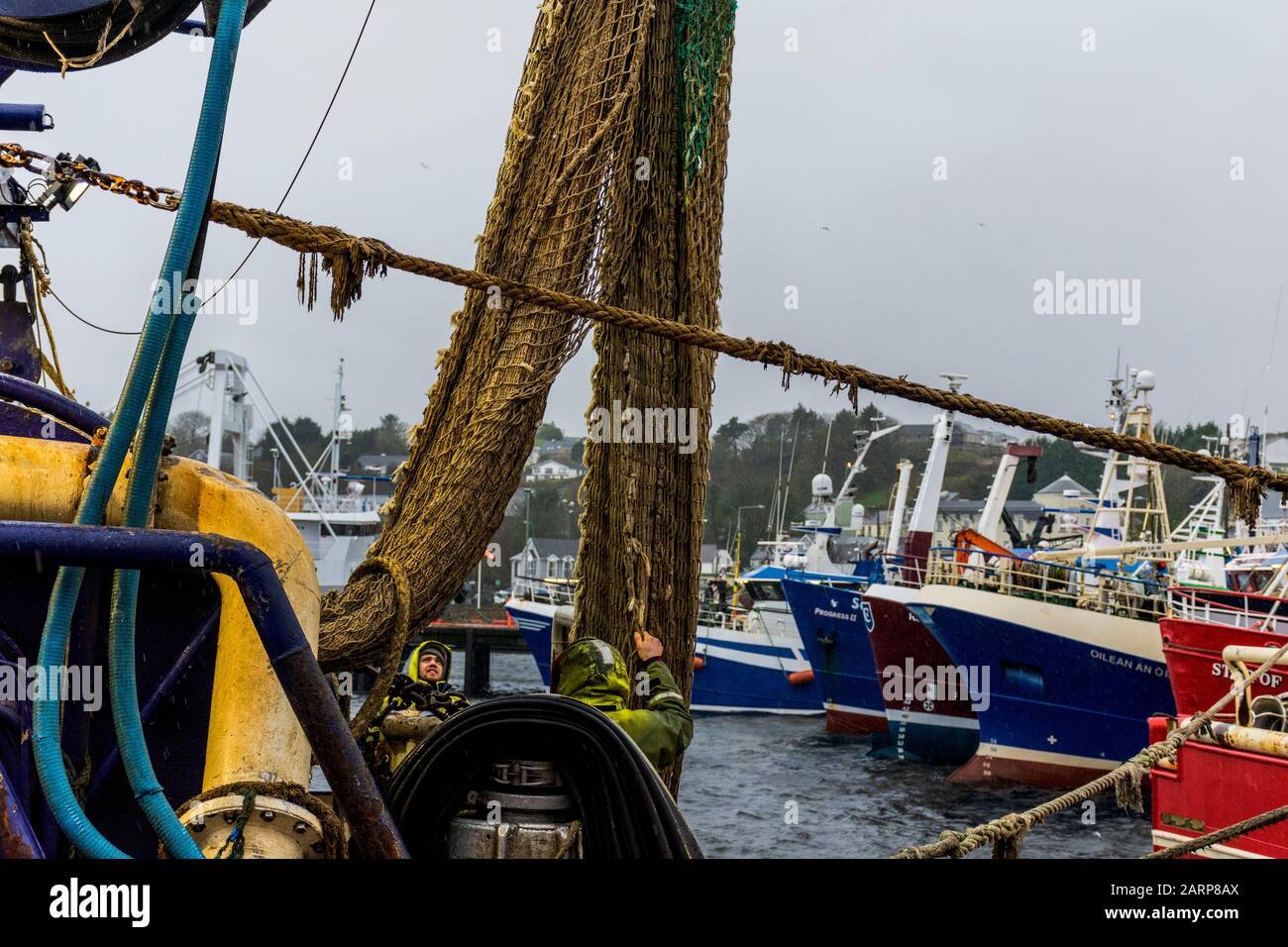 Killybegs, Contea di Donegal, Irlanda. 29 gennaio 2020. I pescatori lavorano sulle loro reti da barca in condizioni di clima piovoso come la Gran Bretagna per introdurre un disegno di legge per porre fine ai diritti di pesca automatici dell'UE nelle acque britanniche. Il futuro accesso al pesce nelle acque britanniche sarebbe una questione che il Regno Unito dovrebbe negoziare e decidere sulle regole che le navi straniere devono seguire. Foto Stock