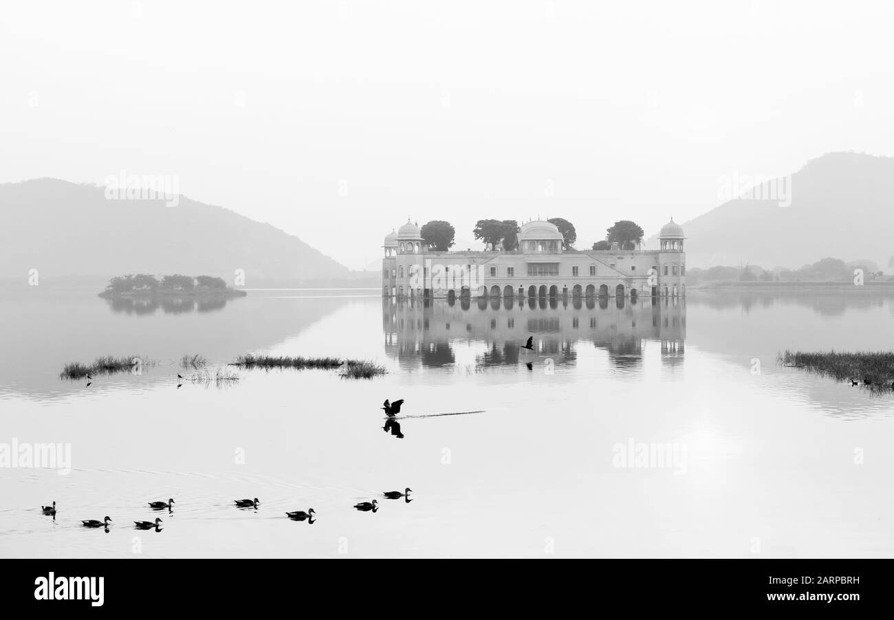 Palazzo reale vuoto circondato da lago e colline di Aravalli come sfondo all'alba a Jaipur, Rajasthan, India. Foto Stock