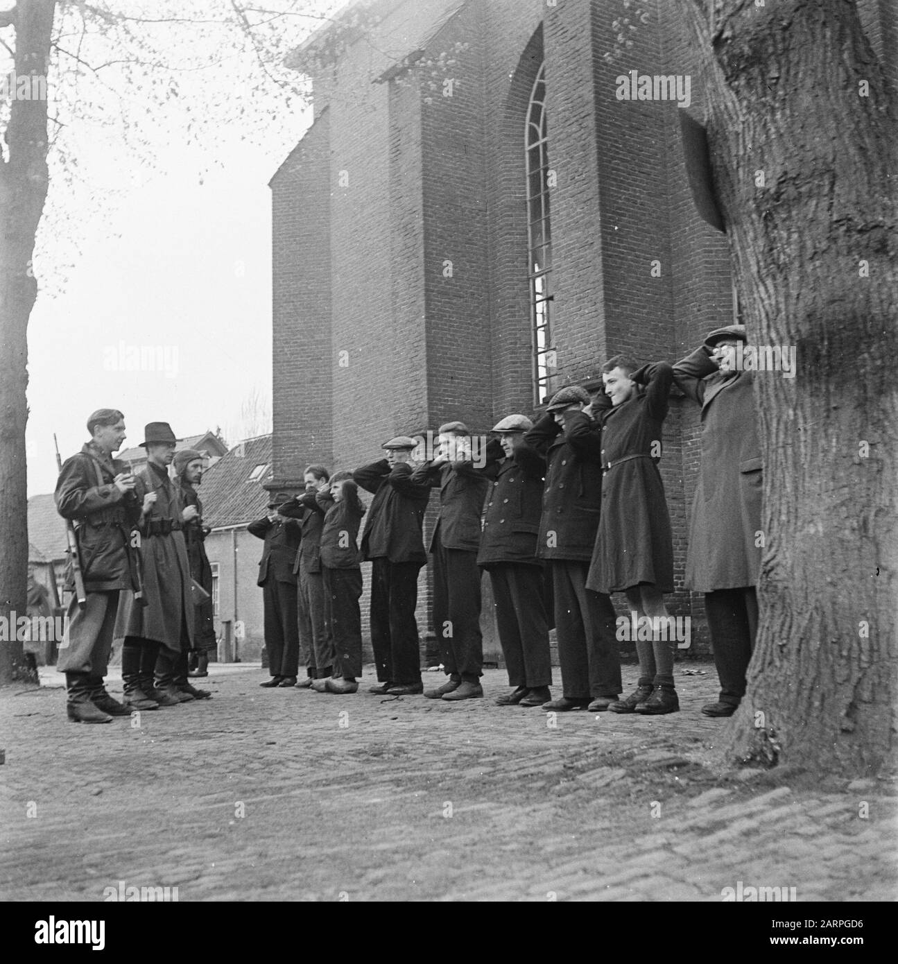 Tre membri del BS (Forze Armate degli interni olandesi) custodire un gruppo di collaboratori in un edificio della chiesa ('t Gooi?). Annotazione: Secondo da destra un ragazzo con pantaloncini e soprabito da donna. Terzo di una sinistra anche un ragazzo su zoccoli Data: Maggio 1945 luogo: Het Gooi Parole Chiave: Liberazione, collaboratori, ragazzi, seconda guerra mondiale Foto Stock