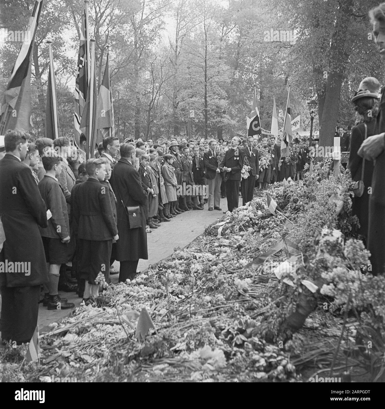 Festa della liberazione: Amsterdam rende omaggio alla memoria delle vittime cadute in rappresaglie per l'attacco a Rauter, il più alto capo della polizia tedesca del nostro paese. Nel Weteringplantsoen dove sono state sparate le vittime, una delegazione di giovani depone i fiori Data: Maggio 1945 luogo: Amsterdam, Noord-Holland Parole Chiave: Cimiteri, fiori, commemorazioni Foto Stock