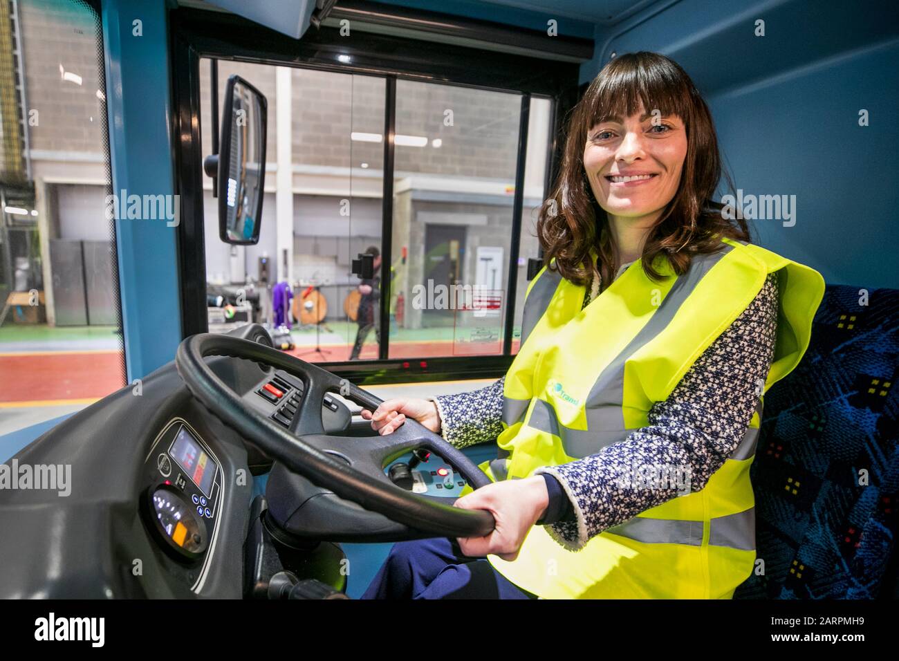 Ministro per le infrastrutture Nichola Mallon seduto dietro il volante di un prototipo di autobus a idrogeno Wrightbus come Translink svela i primi autobus sostenibili per celle a combustibile dell'Irlanda del Nord alimentati dall'energia eolica presso il suo Milewater Service Centre a Belfast. Foto Stock