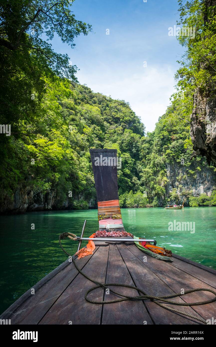 Una barca a coda lunga entra in una laguna appartata nella Baia di Phang Nga, Thailandia Foto Stock