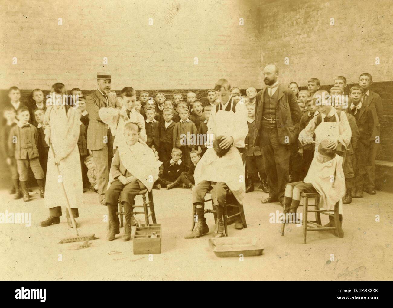 Bambini che tagliano i capelli di altri bambini, Regno Unito 1890s Foto Stock