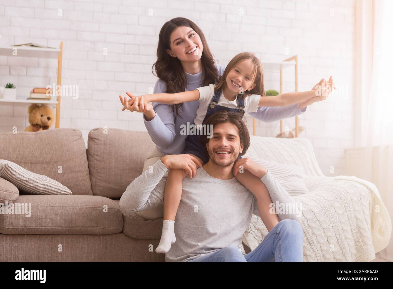 Buona famiglia che si diverte e posa in soggiorno a casa Foto Stock