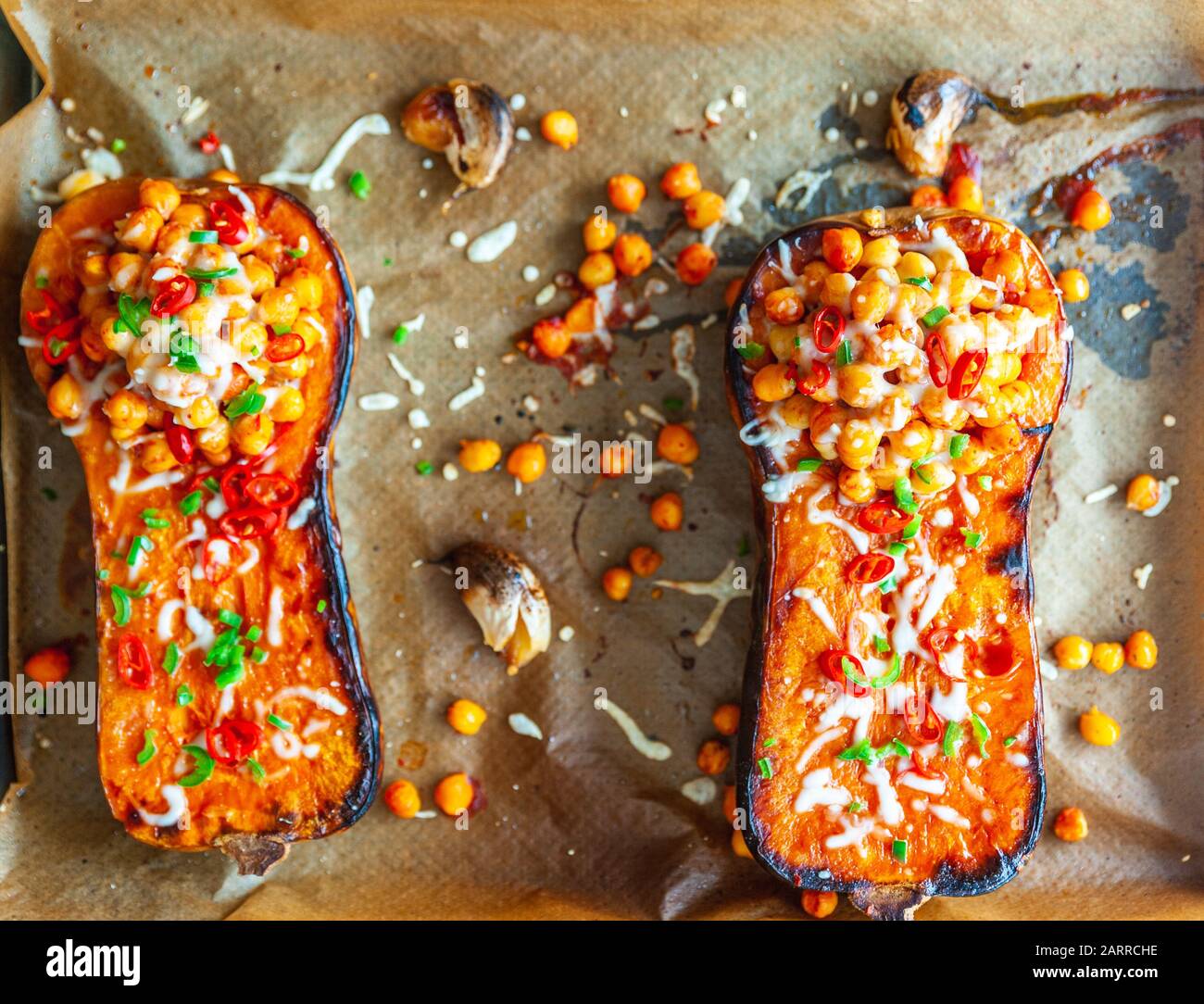 Colpo di testa di una zucca di butternut arrostita condita con ceci, pepe e formaggio Foto Stock