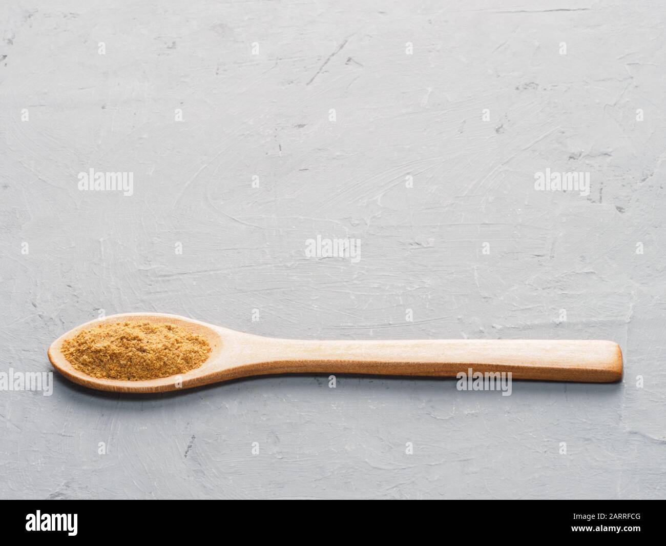 Spice masala in cucchiaio di legno sul cemento grigio Sfondo. La cucina indiana, Ayurveda, naturopatia il concetto Foto Stock