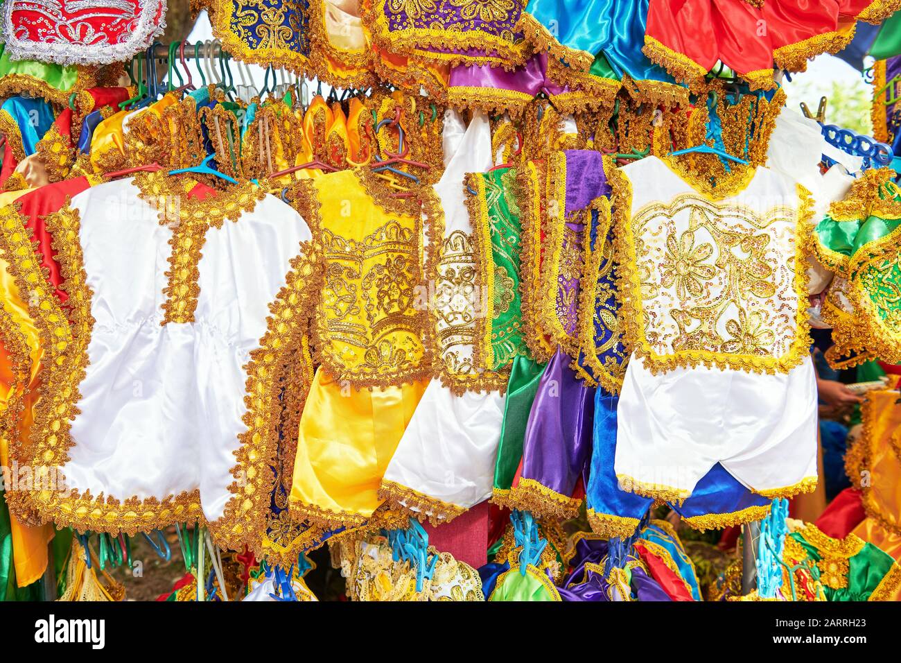 Colorati abiti festosi fatti a mano per bambini sono venduti in onore di Santo Nino in uno stand al Festival Ati-Atihan a Ibajay, Filippine Foto Stock
