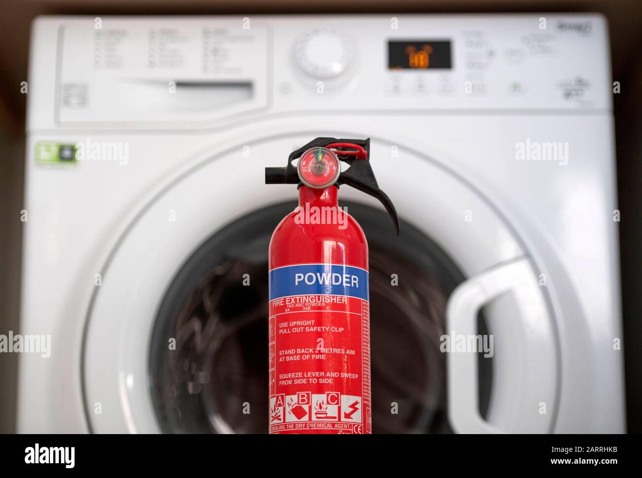 Una lavatrice Hotpoint che è su una lista di richiamo di apparecchi incendiati con un estintore. Si tratta di una delle numerose macchine che possono provocare incendi a causa di un meccanismo di porta surriscaldato. Circa il 20% delle lavatrici Hotpoint e Indesit vendute dal 2014 sono interessate da un guasto di sicurezza e devono essere richiamate. Foto Stock