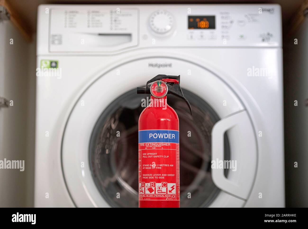 Una lavatrice Hotpoint che è su una lista di richiamo di apparecchi incendiati con un estintore. Si tratta di una delle numerose macchine che possono provocare incendi a causa di un meccanismo di porta surriscaldato. Circa il 20% delle lavatrici Hotpoint e Indesit vendute dal 2014 sono interessate da un guasto di sicurezza e devono essere richiamate. Foto Stock