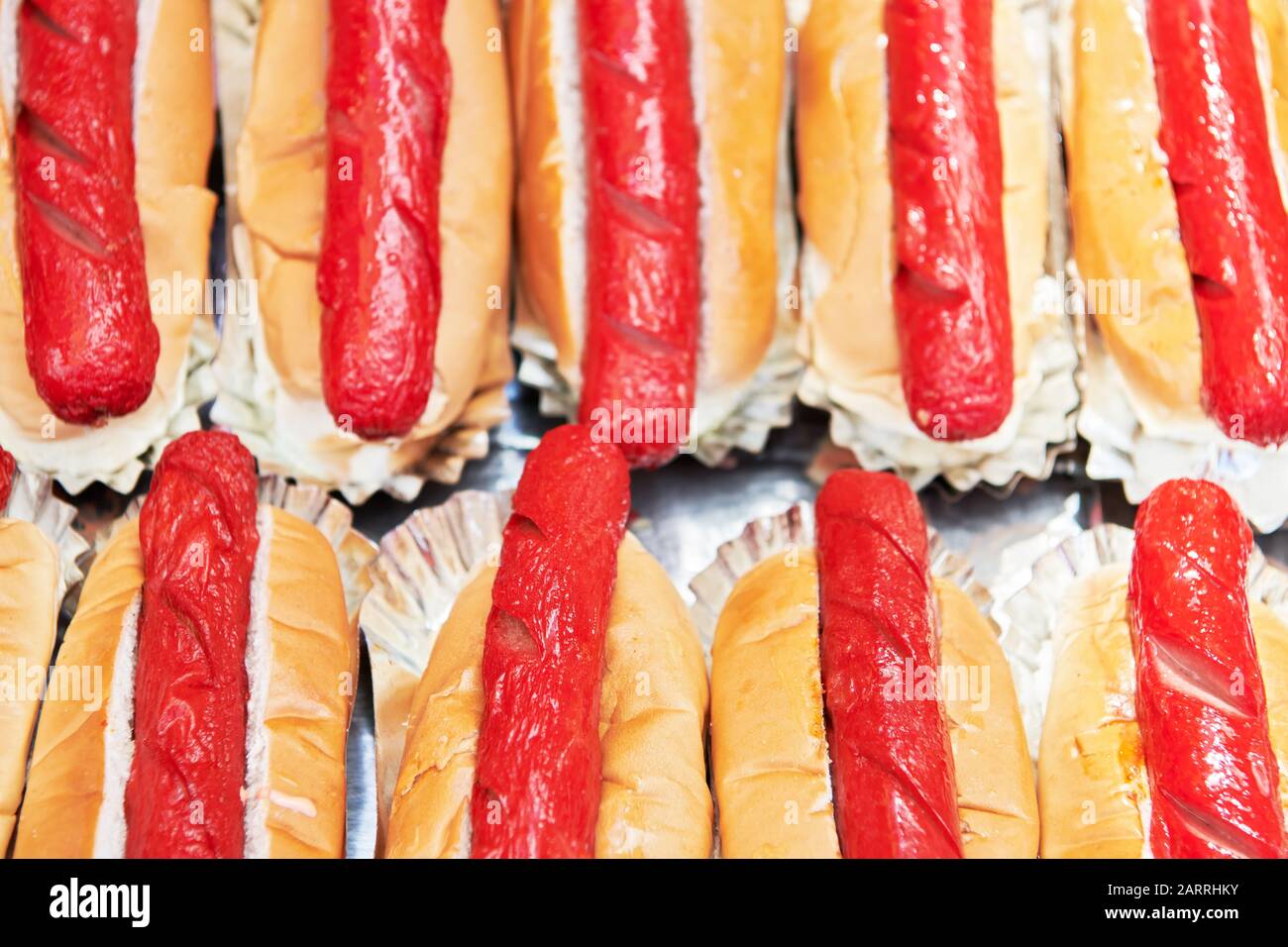 Molti cani caldi preparati avvolti in un pane dolce, pronto per la vendita a un stand alimentare durante un fiesta.Tipica malsana cibo di strada a buon mercato nelle Filippine Foto Stock