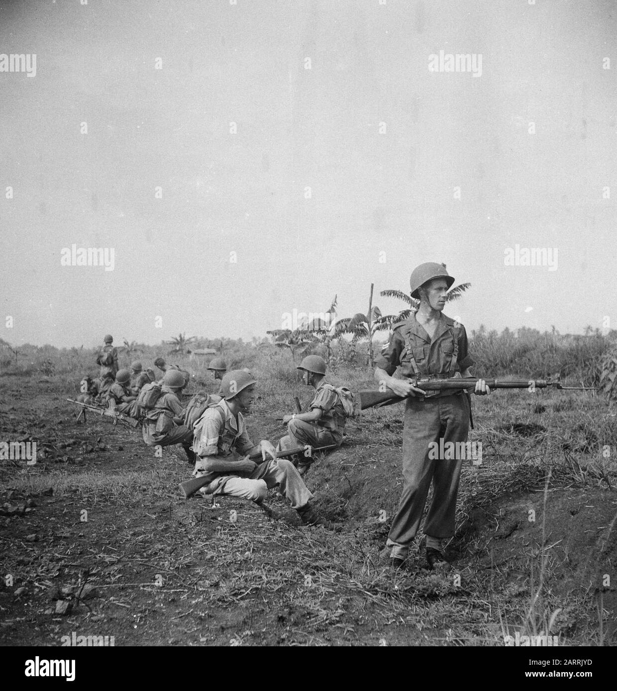 V.P.T.L. [sezione riposo militare. Un soldato continua a guardare] [Pattuglia Di Riposo lungo la strada di marzo. Posti eccezionali con baionetta sul fucile, L'ARMA SULL'UOMO, e... Guardando avanti a tutte le direzioni. Questa pattuglia non fornisce abbastanza copertura facciale] Annotation: V.P.T.L. = prescrizione per l'esercizio dell'attività di polizia Politica dell'esercito (azione contro i combattenti della guerriglia). Questa regola di KNIL risale al 1928, apparsa nel 1936 e fu modificata e integrata nel 1945 e pubblicata nuovamente nel 1946, ora soprattutto per il KL. La serie di foto è stata utilizzata per la brochure Knowledge of the Foto Stock