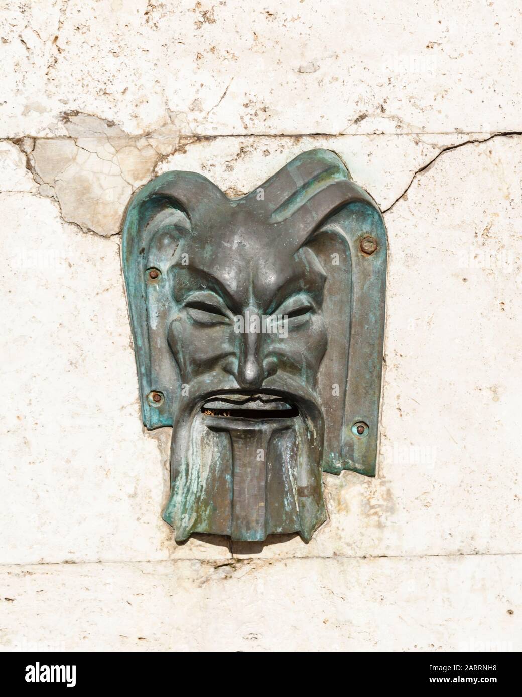 Rilievo muretto in bronzo di un volto in pietra a Foligno, Itally Foto Stock