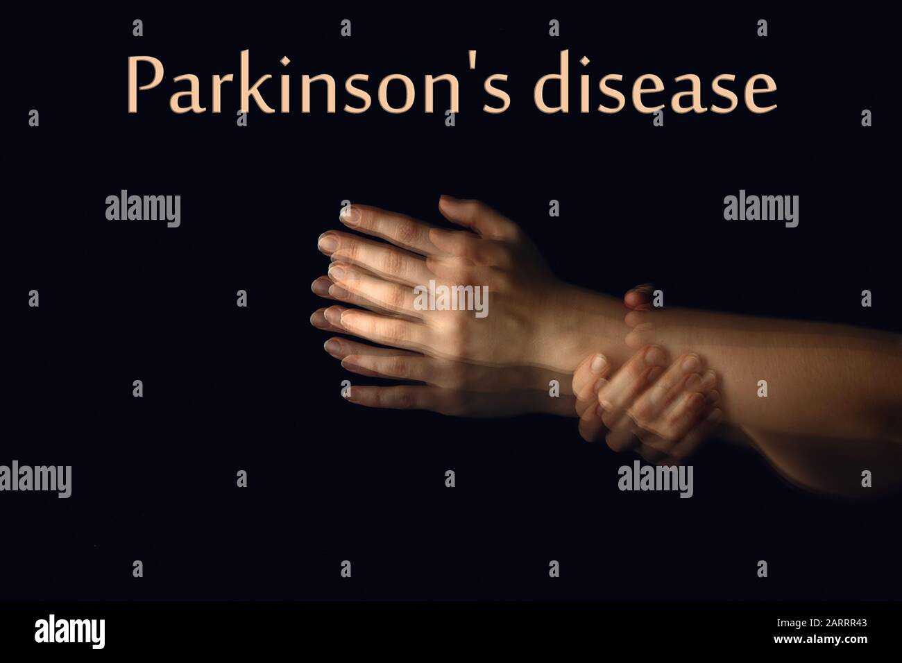 Tremando mani e testo MORBO DI PARKINSON su sfondo scuro Foto Stock