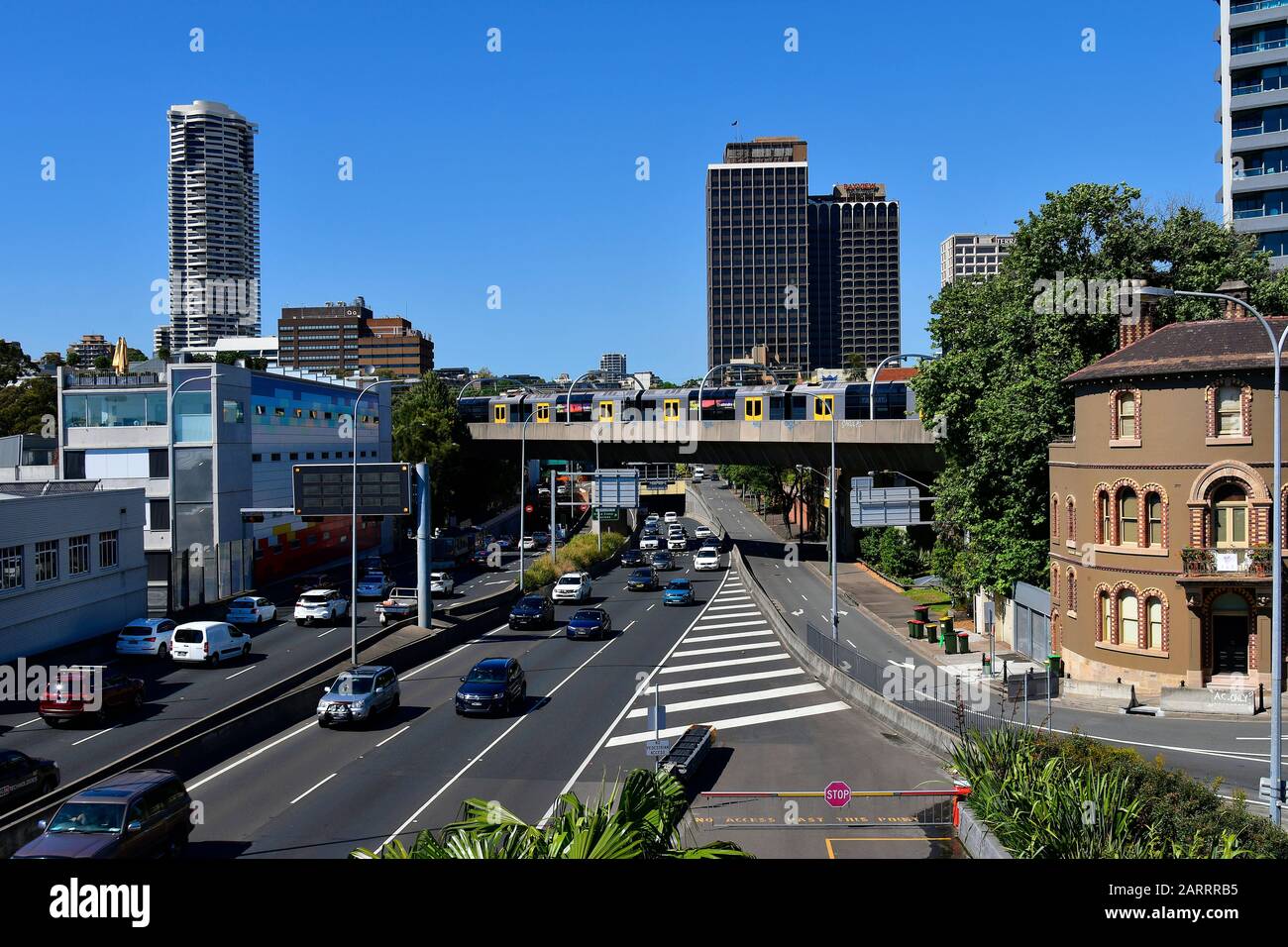 Sydney, NSW, Australia - 30 ottobre 2017: Traffico sul distributore orientale e ponte di attraversamento ferroviario pubblico, con edifici e appartamenti Horizon Foto Stock