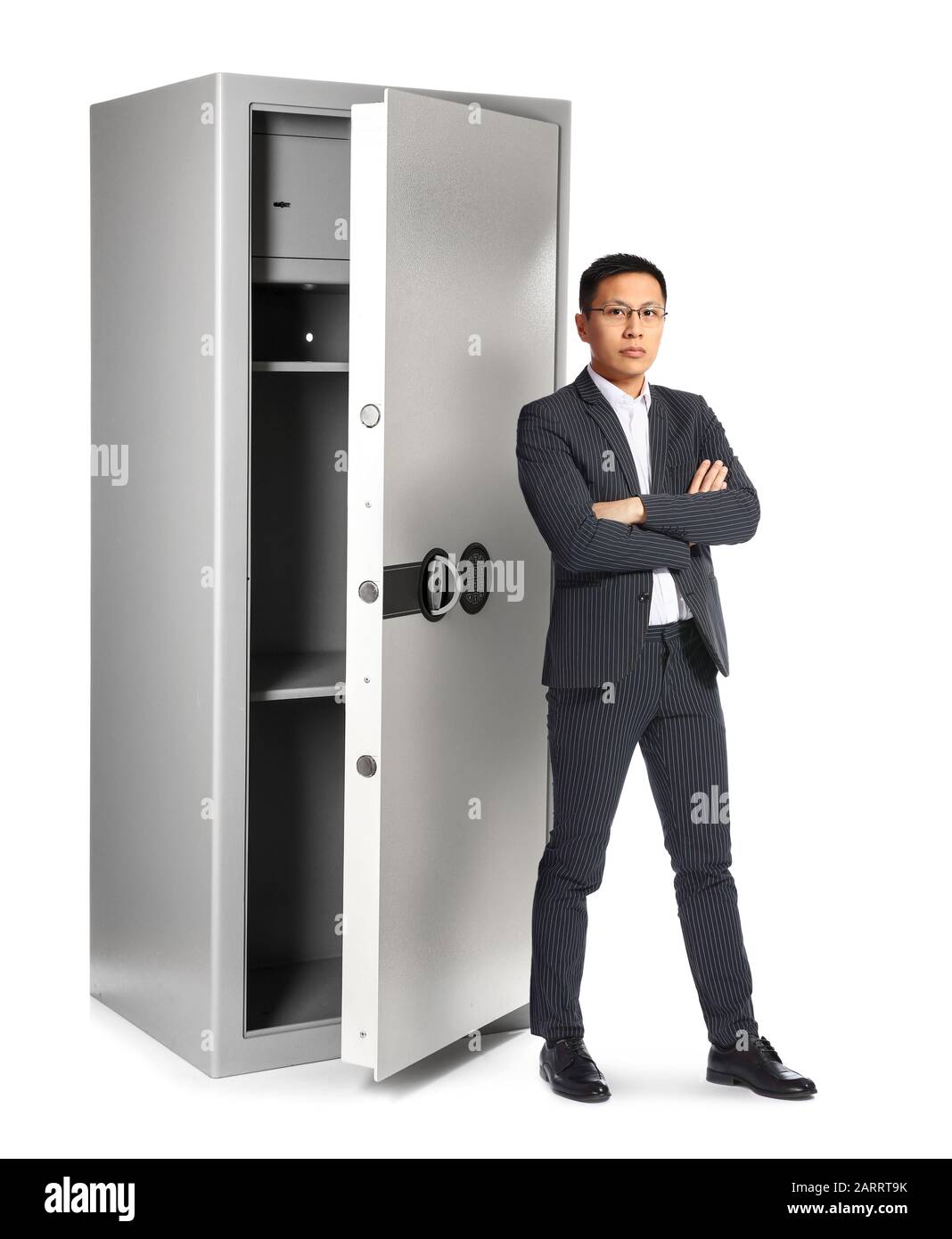 Uomo d'affari asiatico vicino a grande cassetta di sicurezza su sfondo bianco Foto Stock