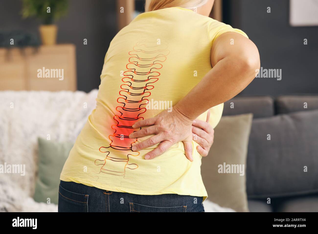 Donna matura che soffre di mal di schiena a casa Foto Stock