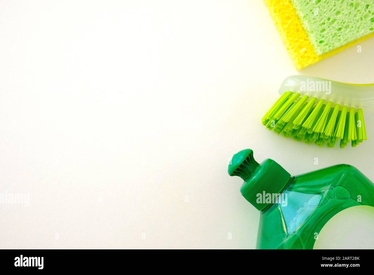 Set di prodotti per la pulizia del verde su sfondo bianco. Detergente in flacone di plastica, spugne e spazzola. Concetto di servizio. Vista dall'alto. Spazio di copia. Foto Stock