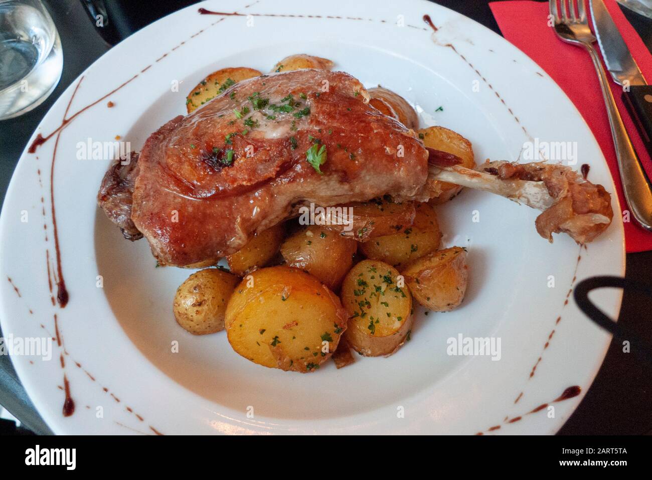 Anatra Confit servito su un letto di patate è una specialità culinaria francese a Parigi, Francia. Foto Stock