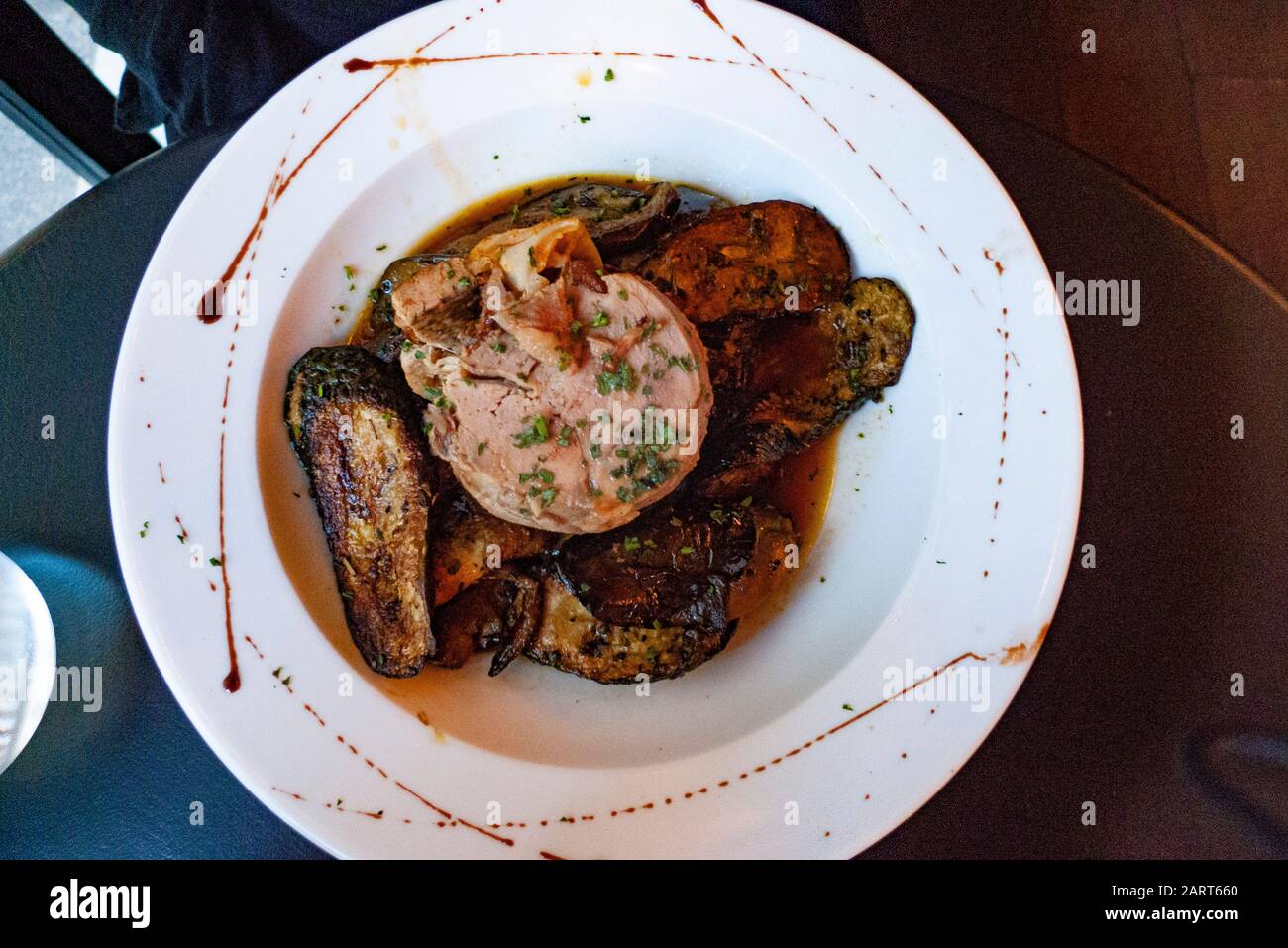 Agnello confit servito su un letto di melanzane a Parigi, Francia. Foto Stock