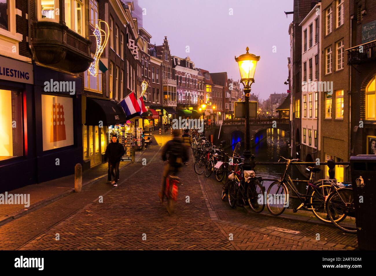 Utrecht, Paesi Bassi, 21st Gennaio 2020. Ponte di pietra ad arco doppio attraverso il canale nel centro di Utrecht. Serata Misty, vista notturna del canale, case Foto Stock