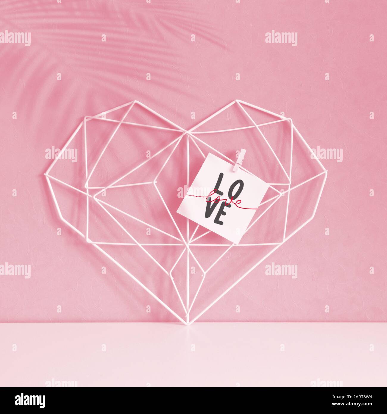 Elegante cuore aperto su sfondo rosa pastello. Minimalismo. Concetto simbolo di amore e San Valentino. Arredamento casa Foto Stock