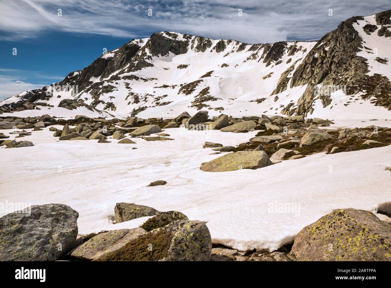 Monte Renoso vetta sul campo di neve, fondendosi a metà maggio, congelato Lac de Bastiani in lontananza, Haute-Corse, Corsica, Francia Foto Stock