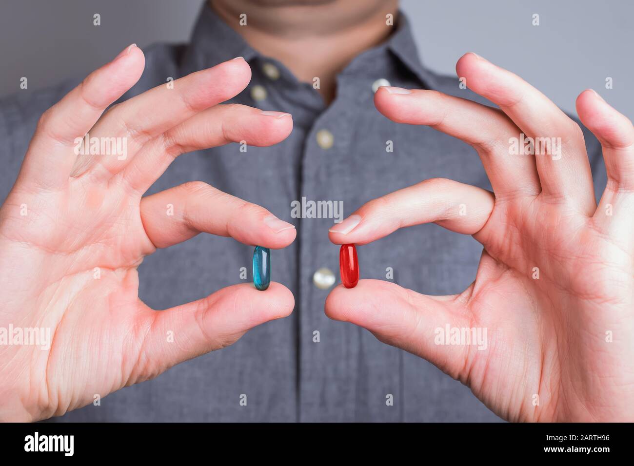 Mani dell'uomo primo piano con pillole rosse e blu Foto Stock