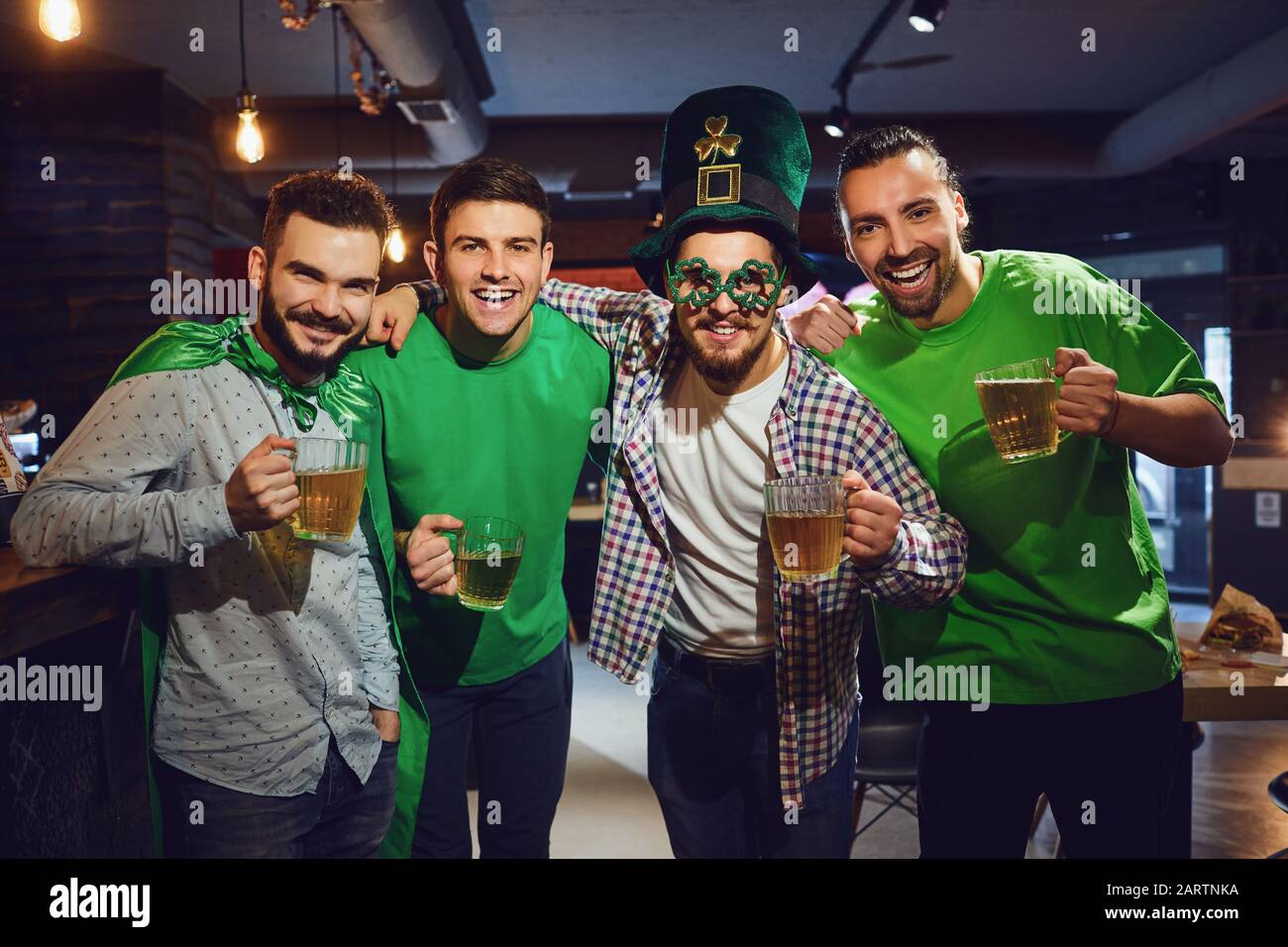 Amici felici che celebrano il giorno di San Patrizio in un bar. Foto Stock