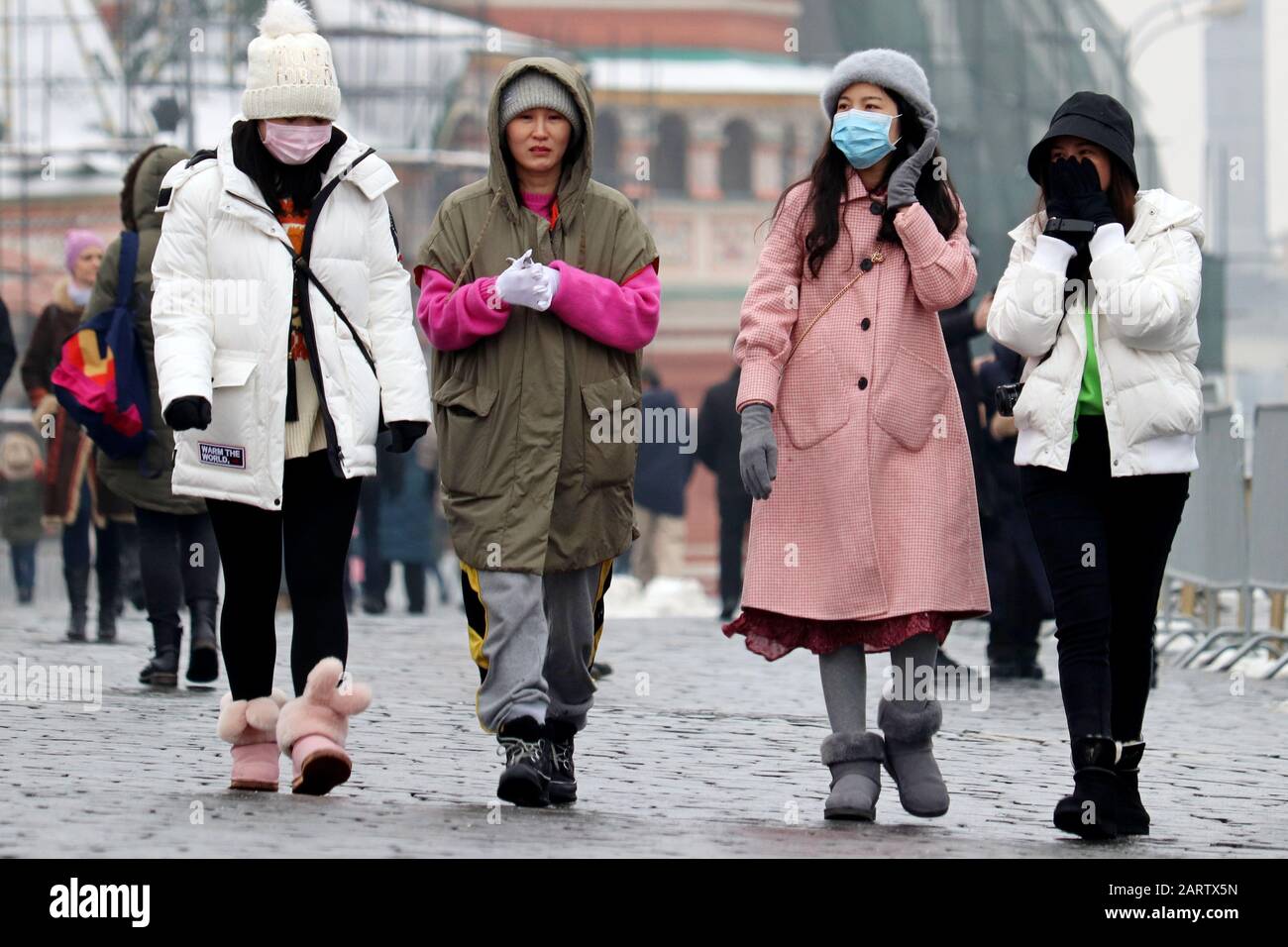 Ragazze cinesi in maschere mediche protettive camminare sulla strada della città. Protezione contro il coronavirus Foto Stock