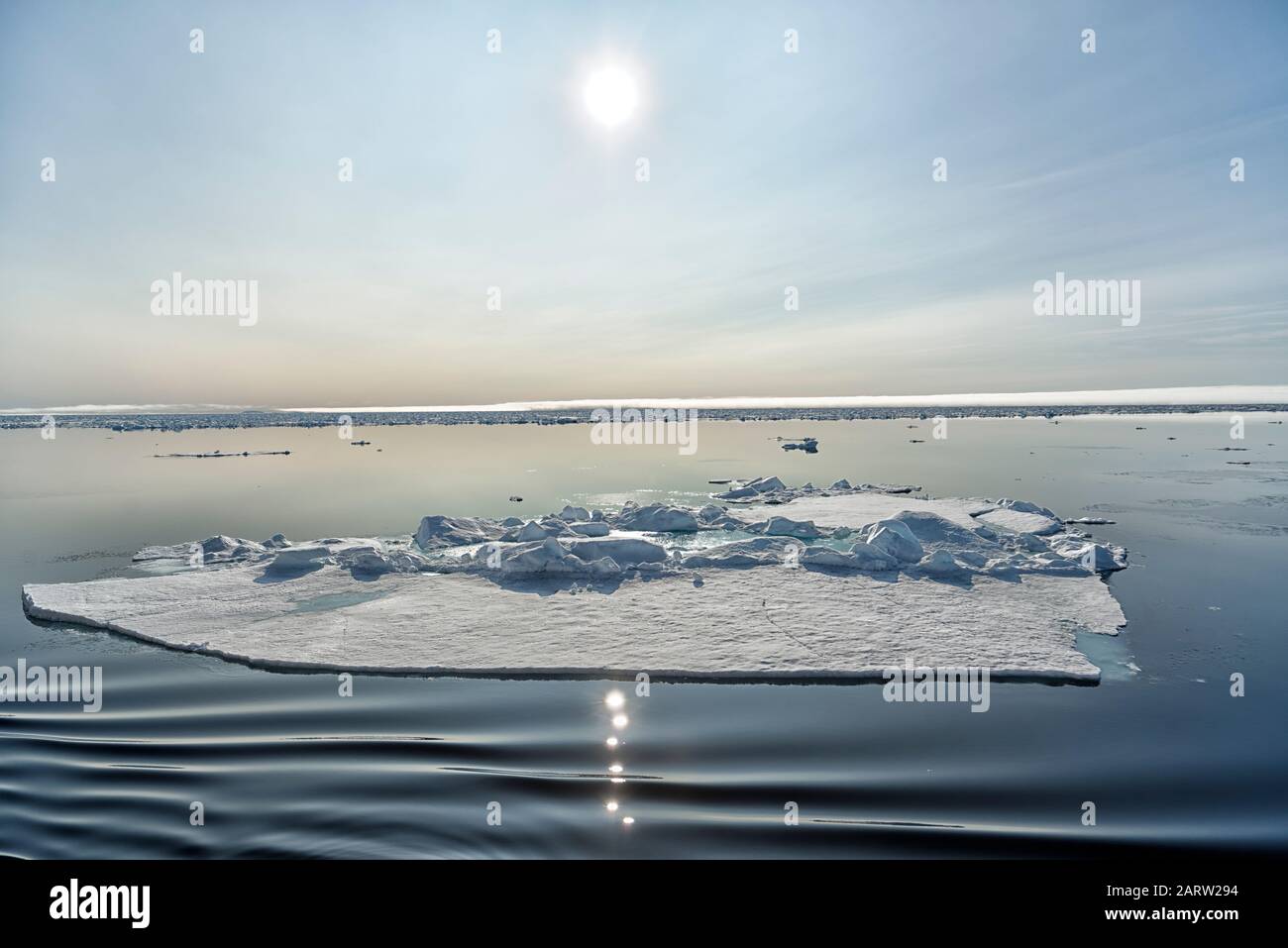 Galleggianti di ghiaccio e riflessione del sole nell'Oceano Artico a nord di Svalbard, Norvegia Foto Stock