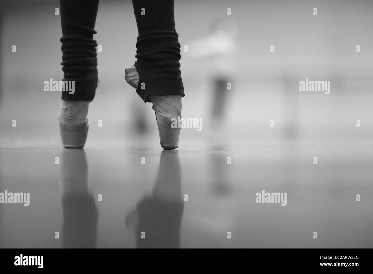 Gambe di una ballerina in piedi su pointe in calze calde in una prova nella  sala Foto stock - Alamy