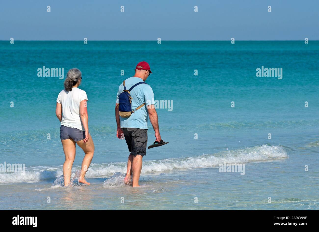 Holmes BEACH, ANNA MARIA ISLAND, Florida - 29 aprile 2018: Una coppia in vacanza facendo una passeggiata sulla spiaggia e godendo di una splendida giornata di sole sul Golfo Foto Stock