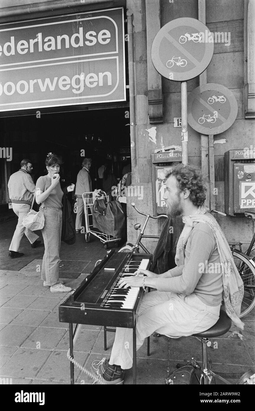 Musicista di strada che suona su un pianoforte elettrico di fronte alla Stazione Centrale di Amsterdam Data: 3 Giugno 1981 Località: Amsterdam, Noord-Holland Parole Chiave: Musicisti di strada, pianoforti Foto Stock