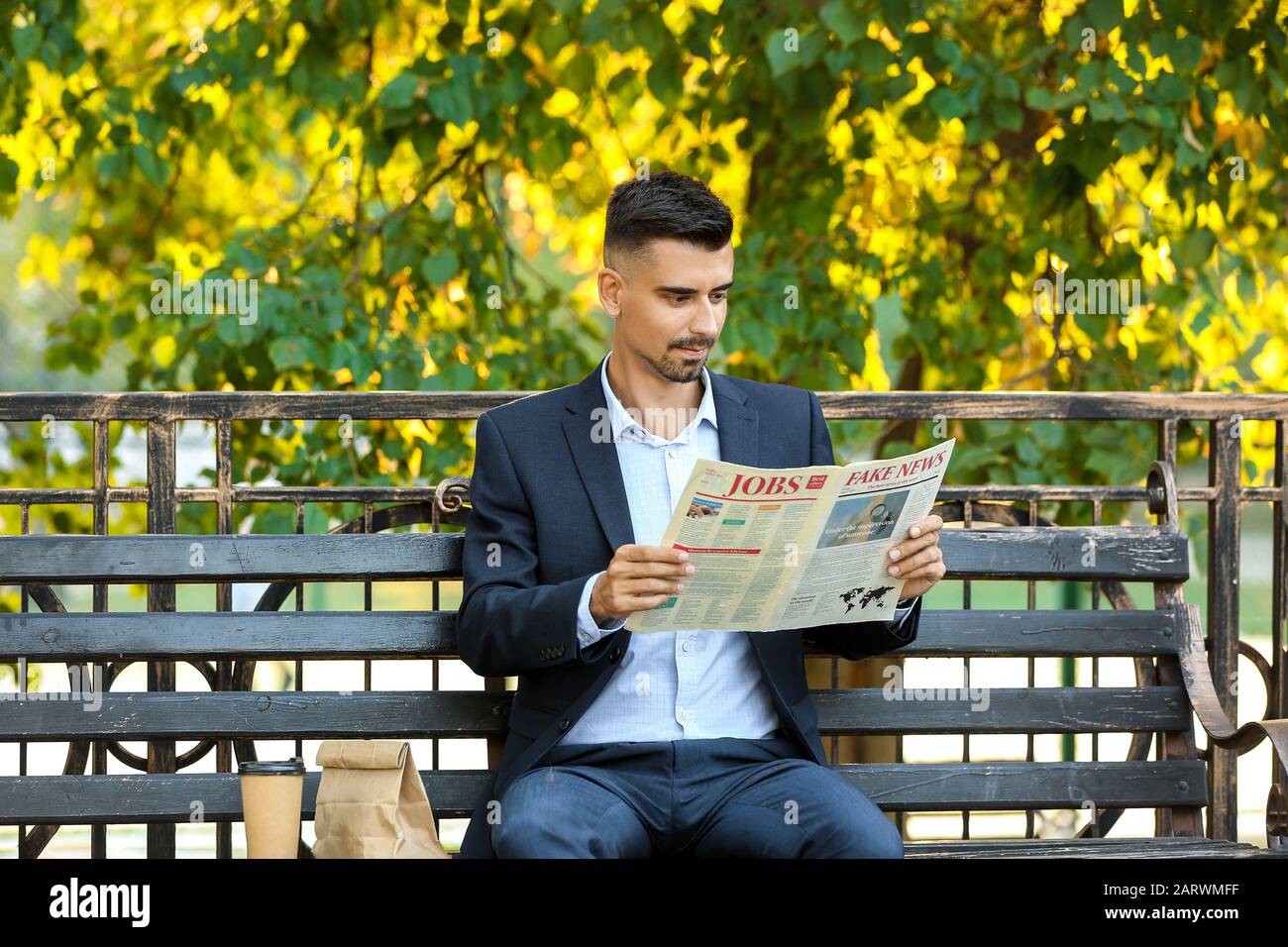 Ritratto di un bel uomo d'affari che legge giornale all'aperto Foto Stock