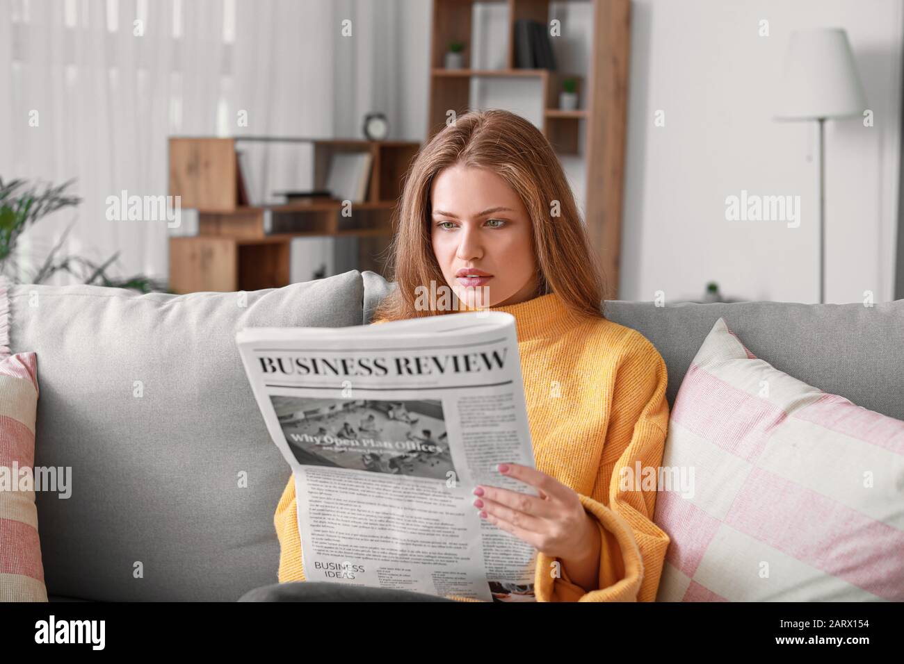 Giovane donna quotidiano di lettura a casa Foto Stock