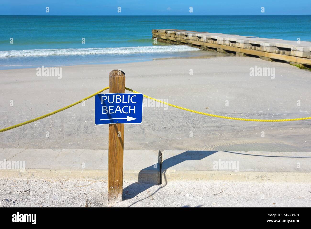 Un segno blu di spiaggia pubblica su un palo con una freccia rivolta verso destra Foto Stock